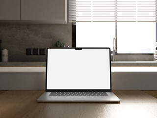 Elegant laptop mockup on a table in a modern kitchen, ideal for website presentation.