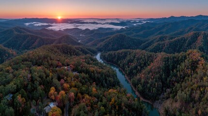Panoramic sunrise over autumnal mountain range and river valley
