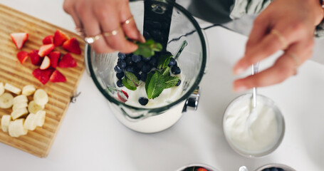 Person, hands and blender with smoothie for diet, healthy drink or meal prep above in home. Top view, nutritionist or recipe mix with ingredients for natural organic beverage or milkshake in kitchen