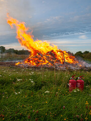 PALDISKI, ESTONIA – AUGUST 22, 2009: Large bonfire burning branches and brushwood in a field...