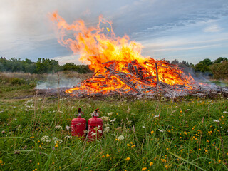PALDISKI, ESTONIA – AUGUST 22, 2009: Large bonfire burning branches and brushwood in a field...