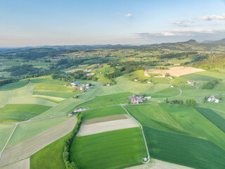 Aerial view of rural landscape in Swiss canton of Fribourg. Hills and forests in evening sunlight in district of Sense.