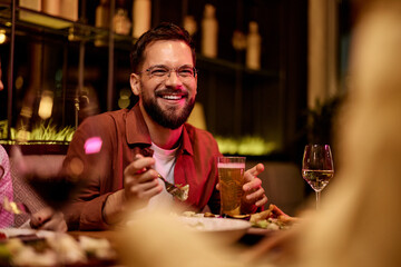 Cheerful Group of Friends Enjoying Dinner and Drinks at a Cozy Restaurant