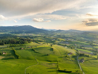 Aerial view of rural landscape in Swiss canton of Fribourg. Hills and forests in evening sunlight in district of Sense.