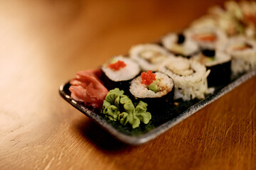 Appetizing Sushi Platter with Fresh Garnishes on a Wooden Table Setting