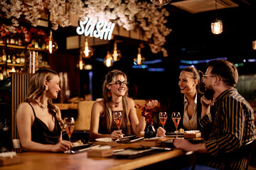 Friends Enjoying Sushi Dinner at a Stylish Restaurant with Lively Atmosphere