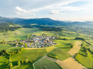Aerial view of rural landscape in Swiss canton of Fribourg. Hills and forests in evening sunlight in district of Sense.