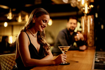 Elegant Woman Holding a Cocktail at a Cozy Bar