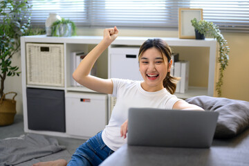 Happy female freelancer cheering after achieving online work milestone