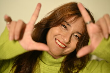 young woman with hands up. making click by fingers in camera. smile emotions