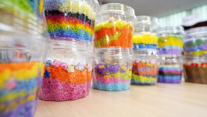 Colorful layered salt art in plastic cups, elementary school craft project
