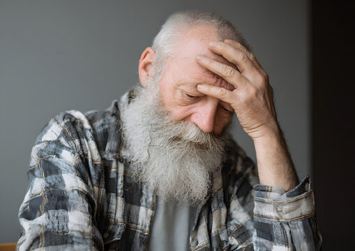 Drown image of losing of mind. Old bearded man with alzheimer desease sitting and suffering from headache. Illness, memory loss due to dementia, healthcare, neurological disorder, depression.