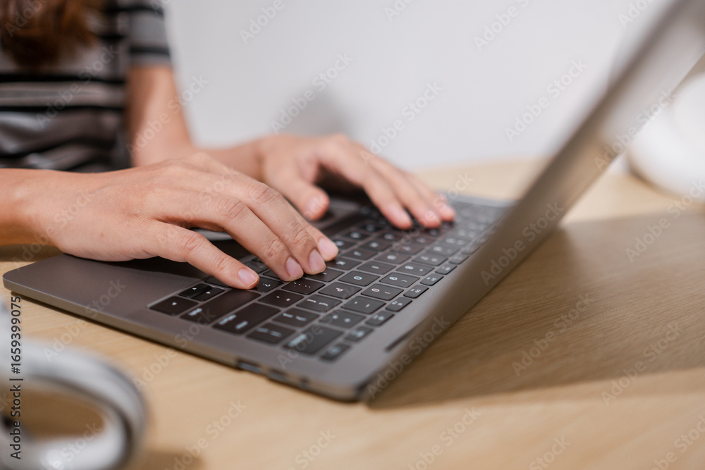 Poster hands typing on a laptop keyboard, showcasing technology and productivity in a modern workspace sett
