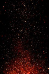 Fiery sparks explode upward against a dark background