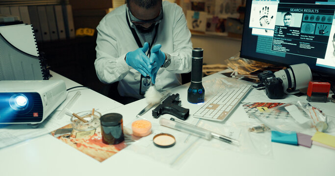 Man, forensics and dust knife for fingerprints, brush and light with tools for evidence at lab. African person, firearm and murder weapon with inspection, police exam or search for criminal identity