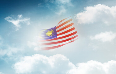 Malaysia flag waving light background hidden in the sky.