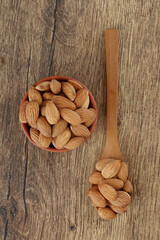 Fresh almonds in earthen pot and wooden spoon