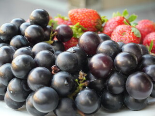 Strawberries and Bali grapes are sweet, juicy fruits enjoyed for their vibrant color and flavor.
