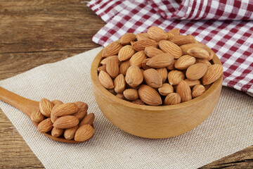 Close up of fresh almonds in wooden bowl