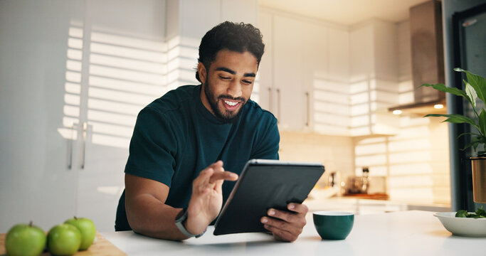 Tablet, happy and man with coffee in kitchen in morning with networking, communication or app. Technology, research and male person with cappuccino for texting, contact or social media in apartment. - Powered by Adobe