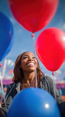 A woman smiles with bright red and blue balloons at a lively daytime festival