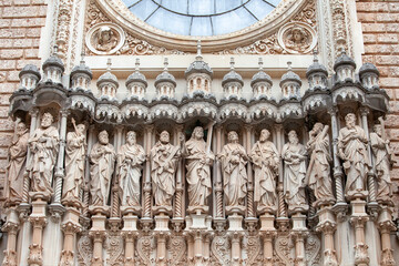 Plateresque Revival stone facade of Basilica of Montserrat with sculptures of saints and rose...