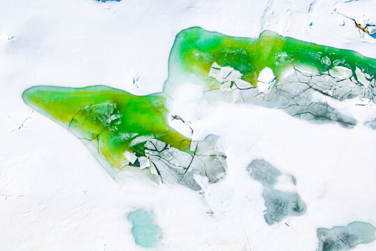 Emerald water in the snow during thaw, Lake Pirola