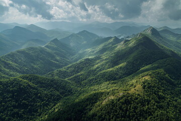 Obraz premium Panoramic view of green mountain valley with rolling hills and clouds, capturing wilderness, nature beauty, fresh air, travel inspiration and serenity