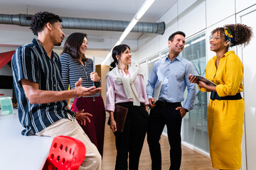 Business people collaborating and discussing in modern office corridor