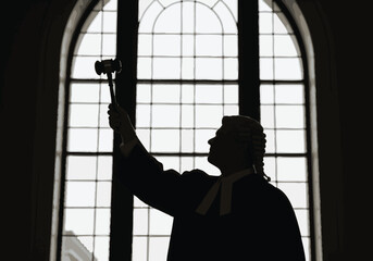 Silhouette of Judge with Gavel and Wig in Courtroom Window Justice System Representation