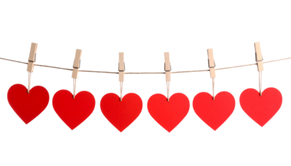 Red paper heart decorations hanging on a string with clothespins for a romantic Valentine's Day