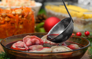 Christmas, dumplings with mushrooms covered with hot red borscht, festive table