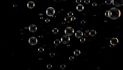 Colorful soap bubbles suspended in the air against a black background