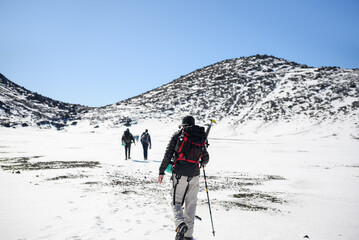 Hiker hiking Tongariro Alpine Crossing on the snow in winter. Unrecognizable people walking in the...