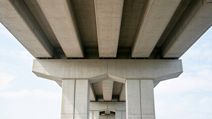 Massive concrete bridge structure showcasing modern engineering and architectural lines against a clear sky