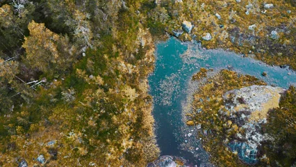 Fototapete Wald Fluss a turquoise river in the middle of a forrest. Norway (Mykland). Top down shot, photographed with a drone.  © Matemato