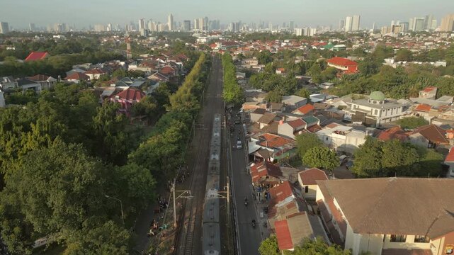 Passenger Train At Sunset Through The Historic Bintaro Curve Jakarta Indoensia Drone Pull Back 4K 60FPS