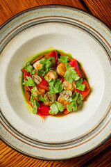 Scallops with vibrant red peppers and fresh herbs create a stunning dish