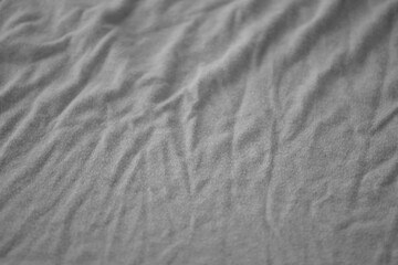 Texture of Dark grey crumpled textile cloth part with small folds