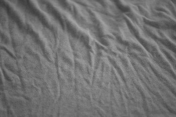 Texture of Dark grey crumpled textile cloth part with small folds