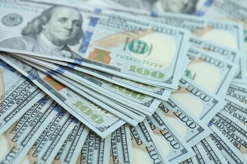 Many hundred dollar bills new banknotes in big pile under the natural light