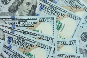 Many hundred dollar bills new banknotes in big pile under the natural light