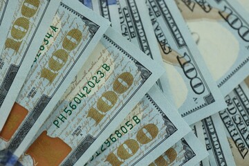 Many hundred dollar bills new banknotes in big pile under the natural light