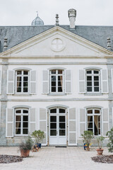 Obraz premium Front view of French château wedding venue with shutters and stone architecture