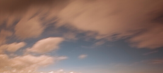 A beautiful sunset sky with dramatic and colorful clouds during twilight. The vibrant gradient of orange, purple, and blue creates a peaceful and romantic atmosphere, perfect for nature backgrounds an