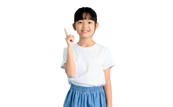 A smiling young girl pointing her finger up in front of a clean background. She is wearing a white shirt and blue skirt on PNG