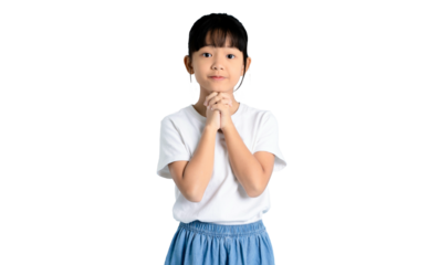 A portrait of an Asian young girl with a sincere expression, clasped hands in front of the chest on PNG