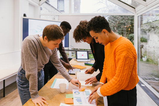 Marketing team analyzing charts and reports in modern office