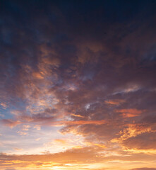 Obraz premium A beautiful sunset sky with dramatic and colorful clouds during twilight. The vibrant gradient of orange, purple, and blue creates a peaceful and romantic atmosphere, perfect for nature backgrounds an