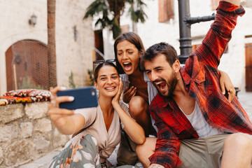 Group of three tourist taking a selfie together while enjoying their trip